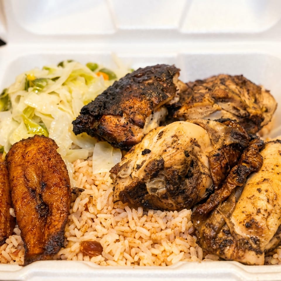 Jerk chicken, rice and peas, steamed cabbage, and plantains in a white takeout container.