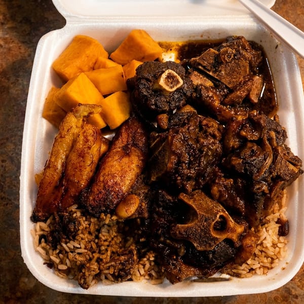 A takeout container filled with oxtail, rice and peas, fried plantains, and cubed squash.